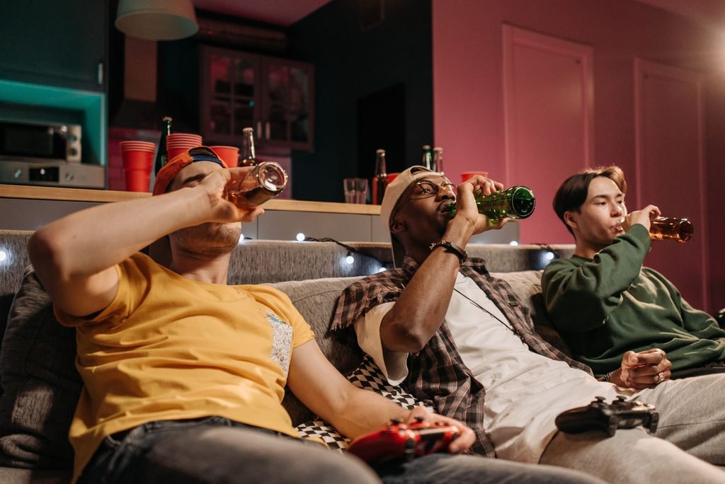 grupo de amigos bebendo álcool em um festa de jogos